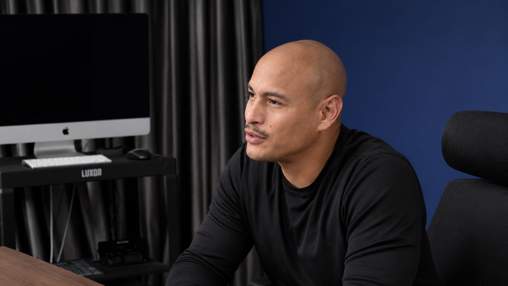 Max Tijerino seated beside a computer monitor