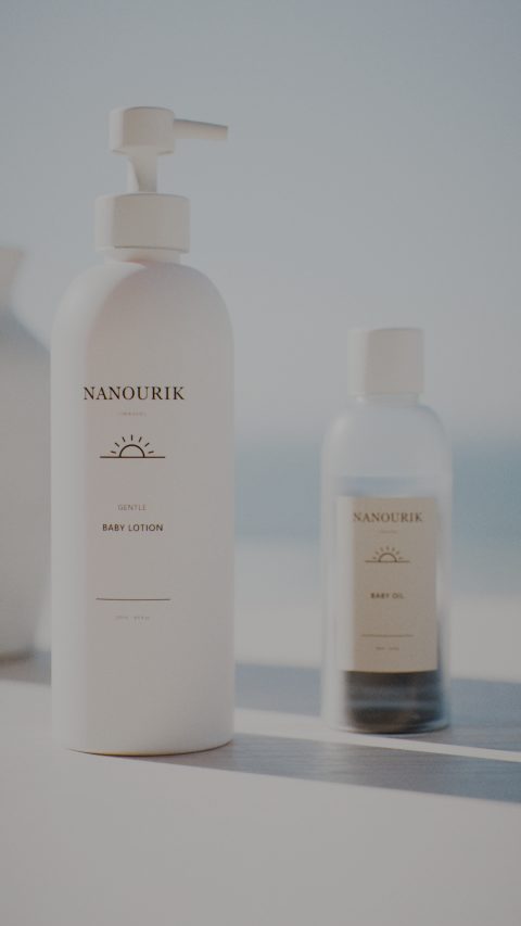 Nanourik lotion and baby oil on a sunlit shelf by the sea